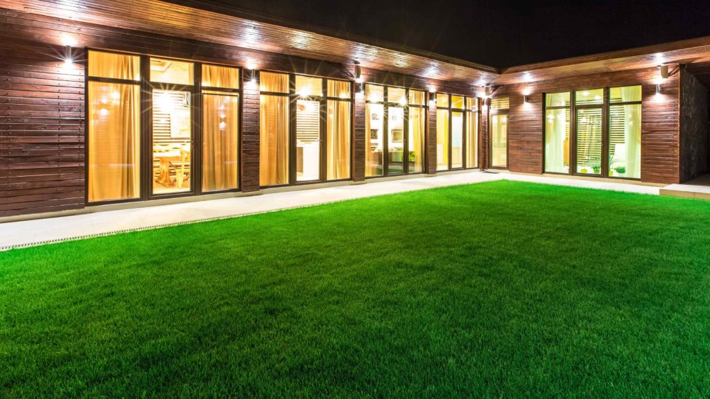 modern home at night lit with indoor and outdoor lighting