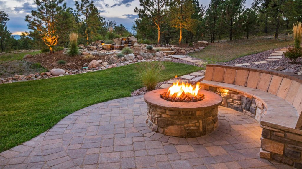 outdoor back yard sitting area with firepit and landscaped lawn