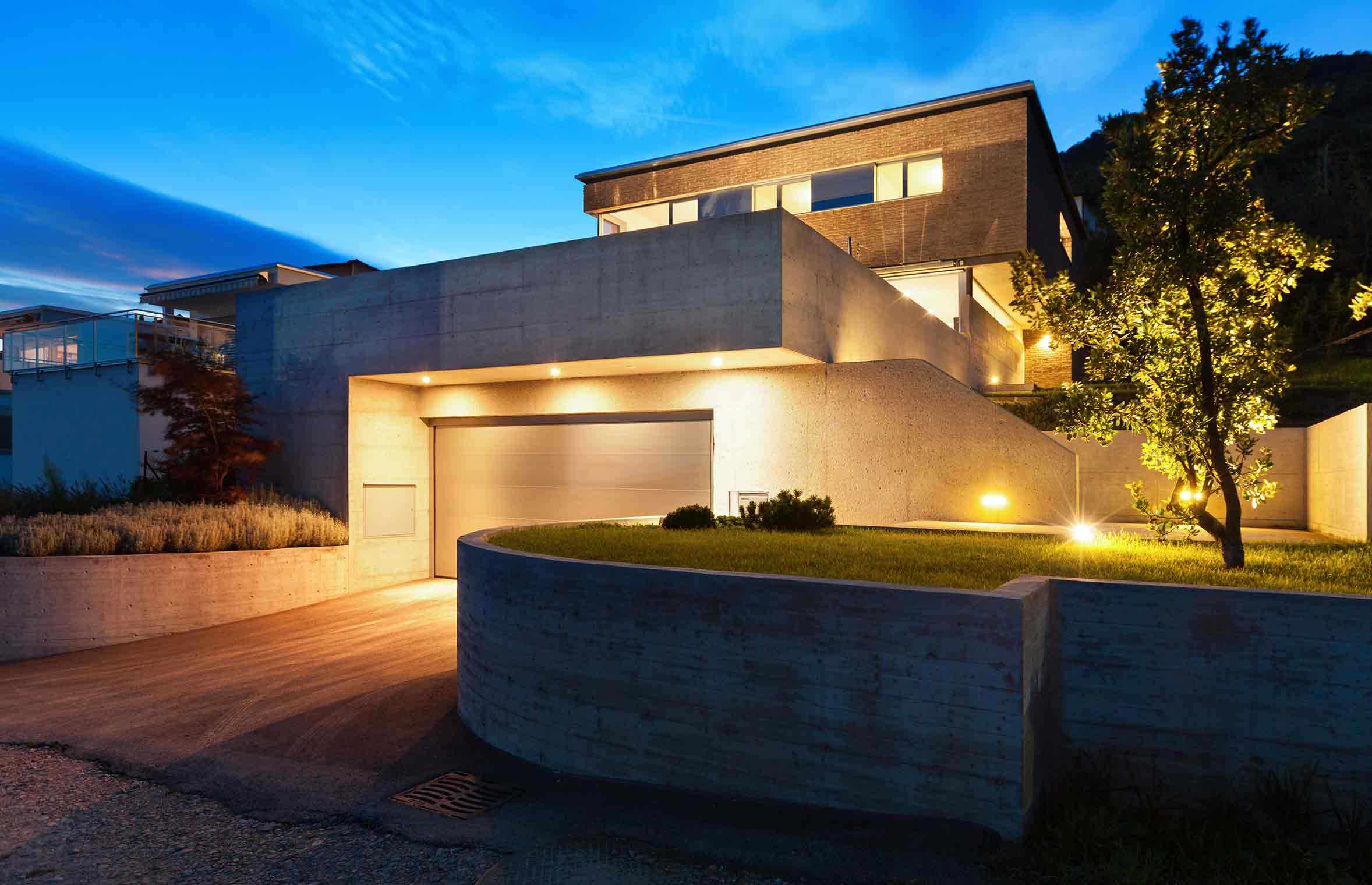 modern home viewed from the street with lighting illuminating the home at night